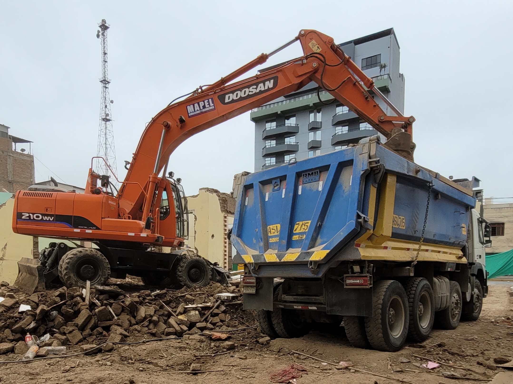 Excavadora Doosan y volquete trabajando en la obra del Edificio Residencial Brescia, San Miguel